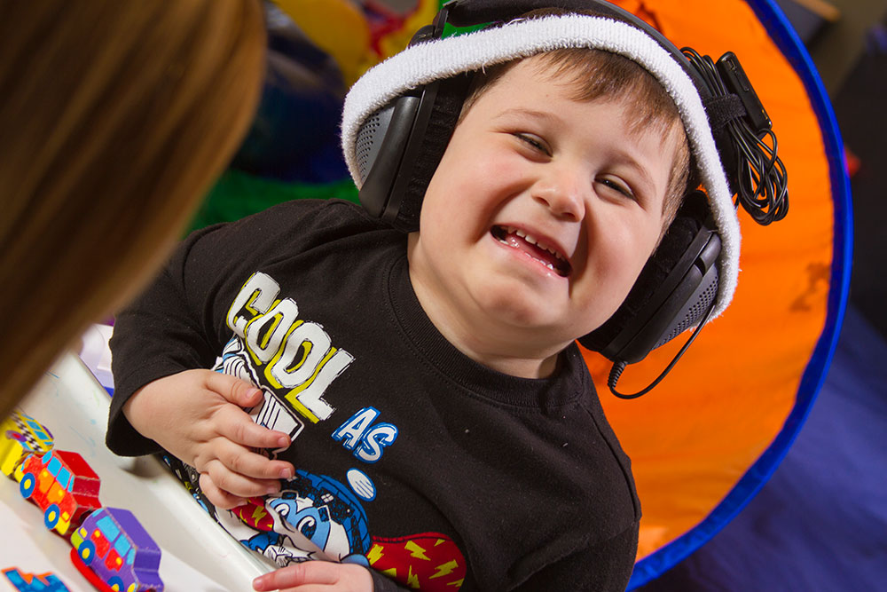 Little boy wearing headphones | speech therapy