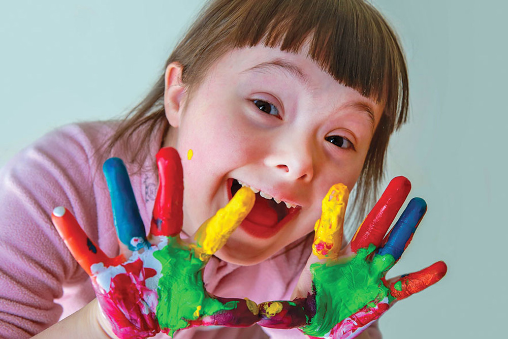 Smiling girl with finger paints